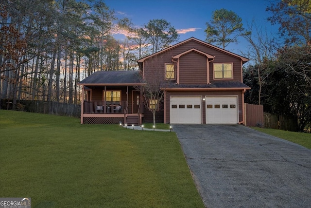 view of front property featuring a garage, a porch, and a yard