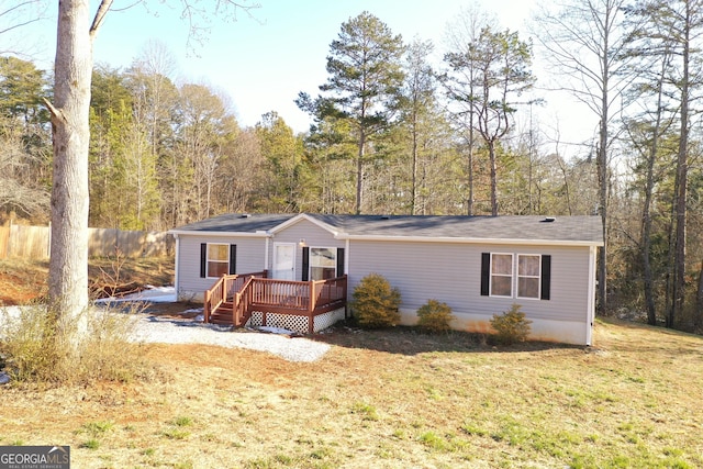 view of front facade featuring a wooden deck and a front lawn