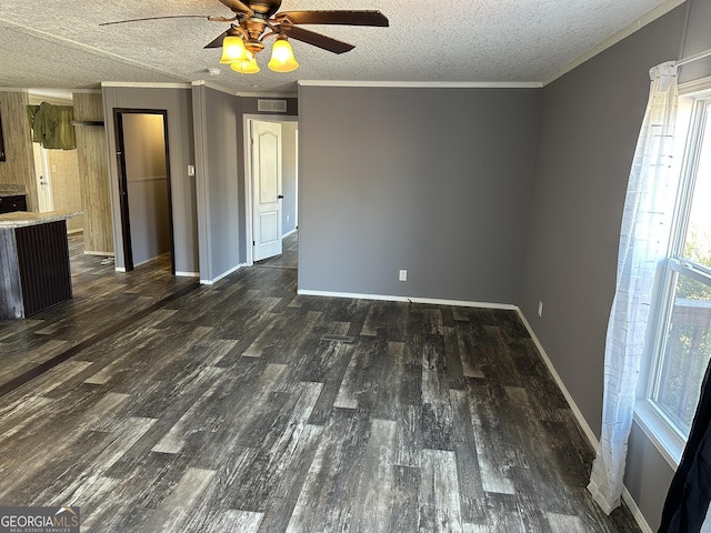 unfurnished living room featuring dark hardwood / wood-style flooring, ornamental molding, and a textured ceiling