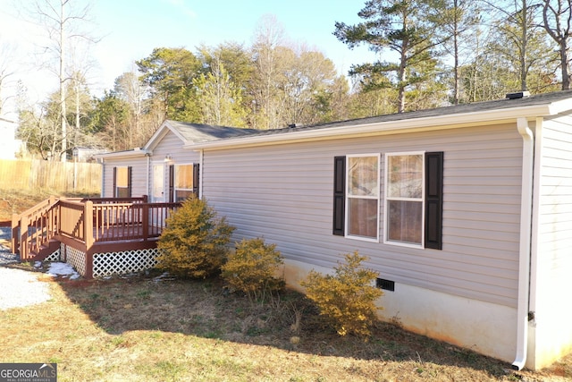 back of property featuring a wooden deck and a yard