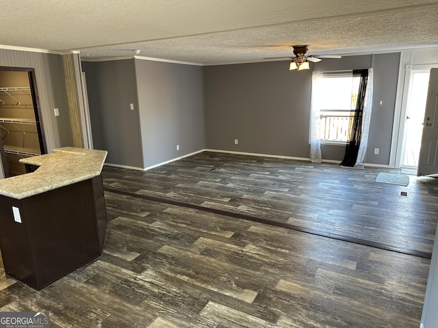 living room with a textured ceiling, ceiling fan, and ornamental molding