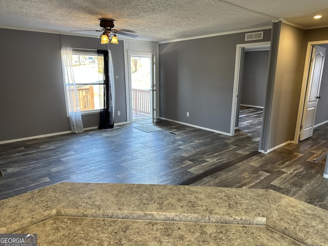 unfurnished room featuring ceiling fan, crown molding, dark wood-type flooring, and a textured ceiling