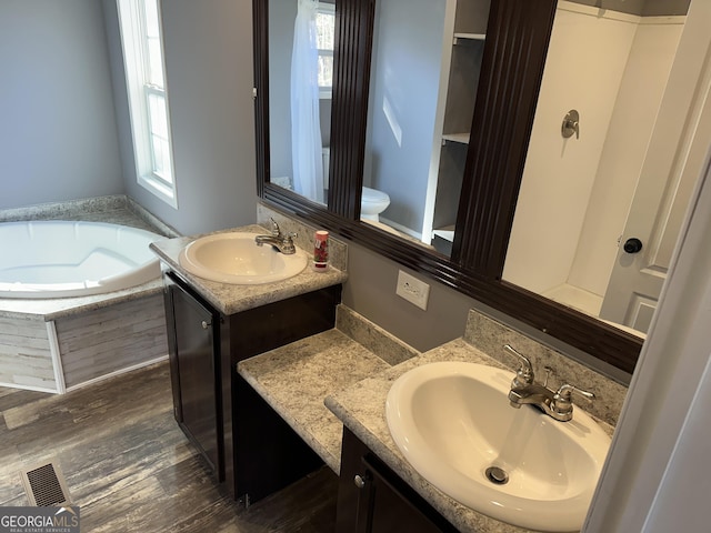 bathroom featuring hardwood / wood-style floors, vanity, a healthy amount of sunlight, and toilet