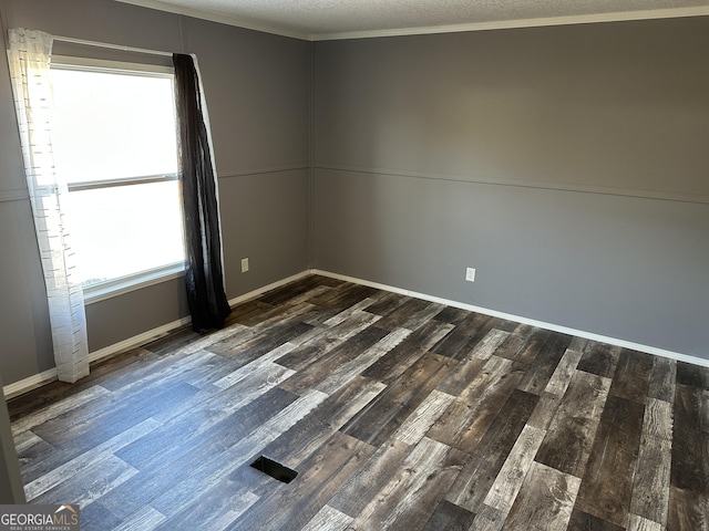 unfurnished room with ornamental molding, a textured ceiling, and dark wood-type flooring