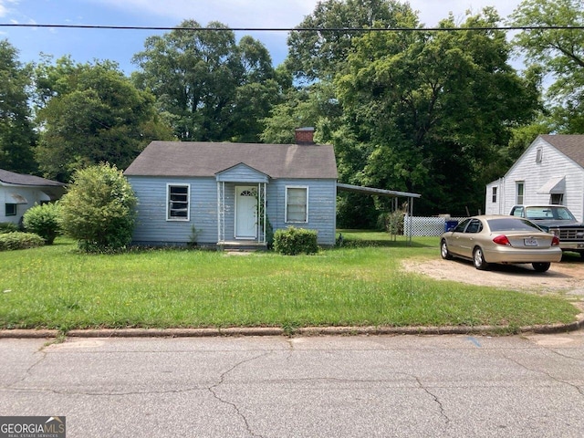 view of front facade with a carport and a front lawn