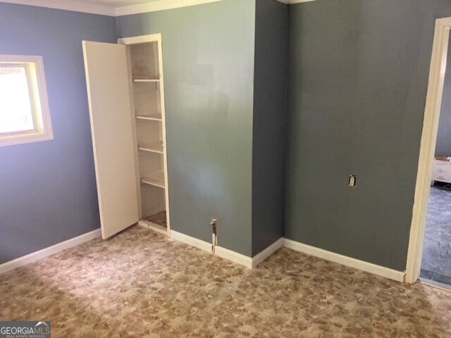 unfurnished bedroom featuring a closet and crown molding