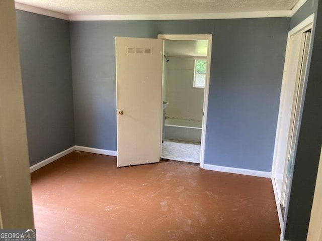 unfurnished bedroom with a textured ceiling and concrete floors