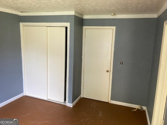 unfurnished bedroom with crown molding, a textured ceiling, and a closet