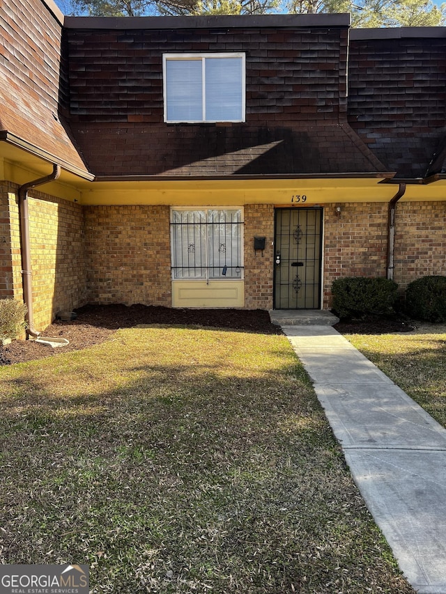 doorway to property with a lawn