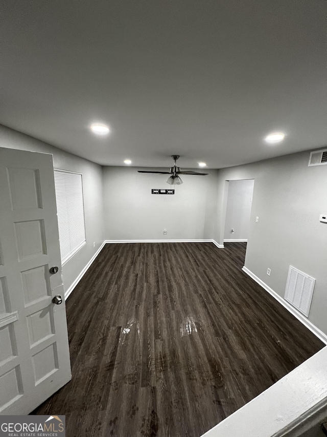 basement featuring ceiling fan and dark hardwood / wood-style floors