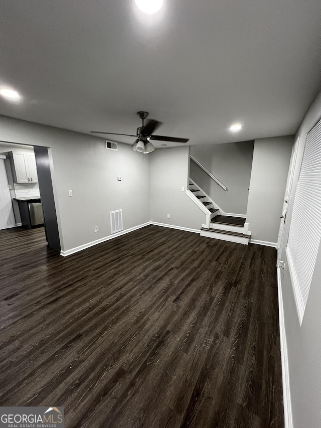 unfurnished living room featuring ceiling fan and dark hardwood / wood-style flooring