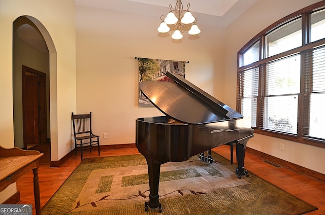 miscellaneous room featuring wood-type flooring and a chandelier