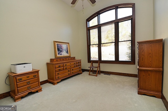 living area featuring ceiling fan, light colored carpet, and vaulted ceiling