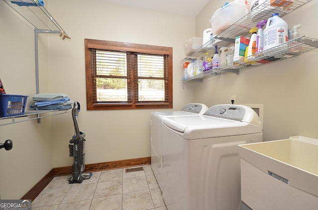 laundry room featuring light tile patterned flooring, separate washer and dryer, and sink