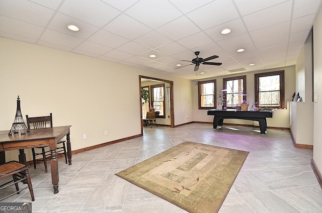 interior space with a drop ceiling and ceiling fan