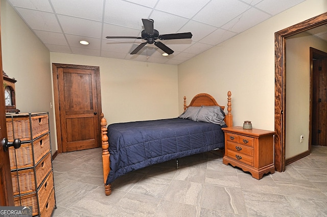 bedroom with ceiling fan and a paneled ceiling