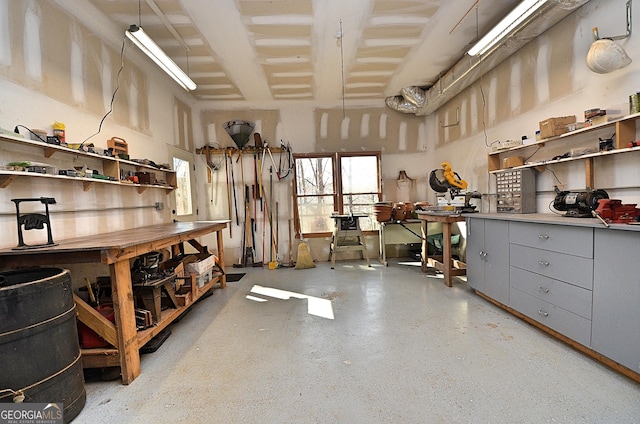 misc room with a towering ceiling and a workshop area