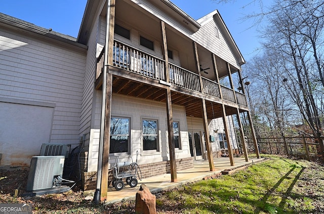 rear view of property with cooling unit and a balcony