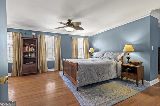 bedroom featuring multiple windows, ornamental molding, and hardwood / wood-style floors