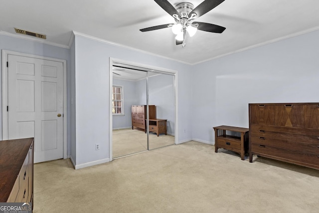 carpeted bedroom with crown molding, a closet, and ceiling fan