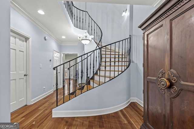 entryway featuring crown molding, a chandelier, and hardwood / wood-style floors