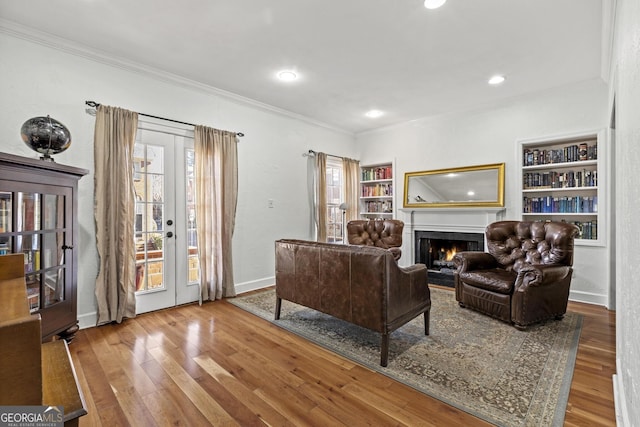 living room featuring french doors, ornamental molding, and hardwood / wood-style flooring