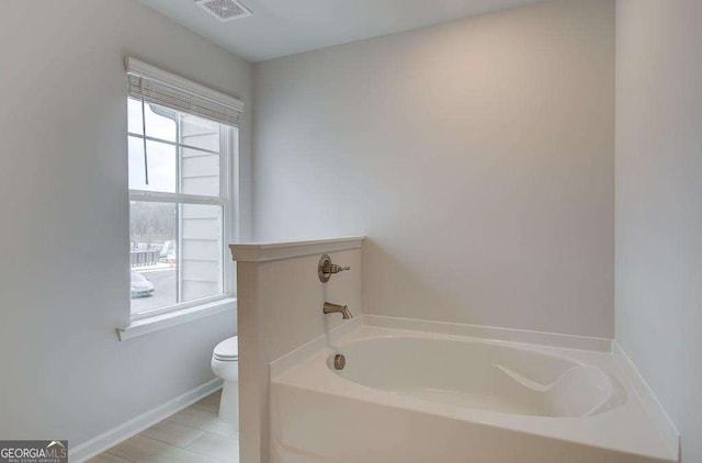 bathroom featuring a bathing tub and toilet