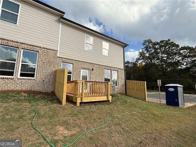 rear view of property with a yard and a deck