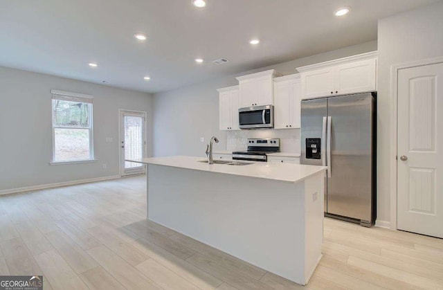 kitchen featuring white cabinetry, a kitchen island with sink, sink, and stainless steel appliances