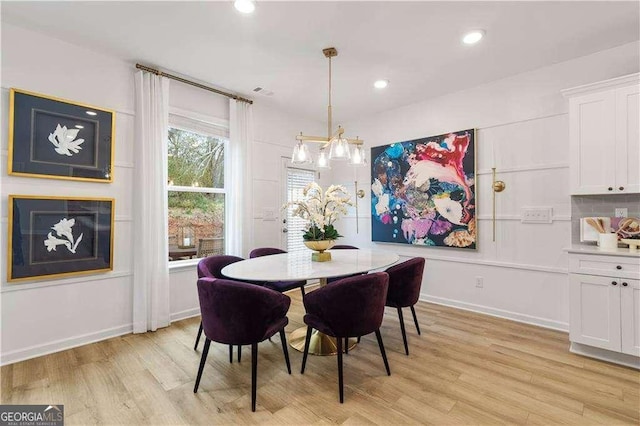 dining space with a chandelier and light wood-type flooring