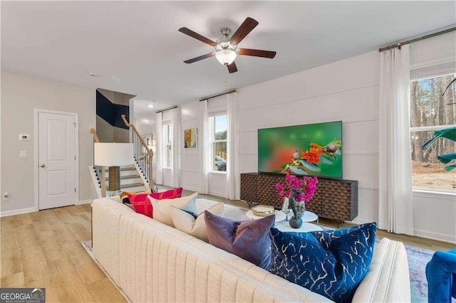 living room with a wealth of natural light, ceiling fan, and light wood-type flooring