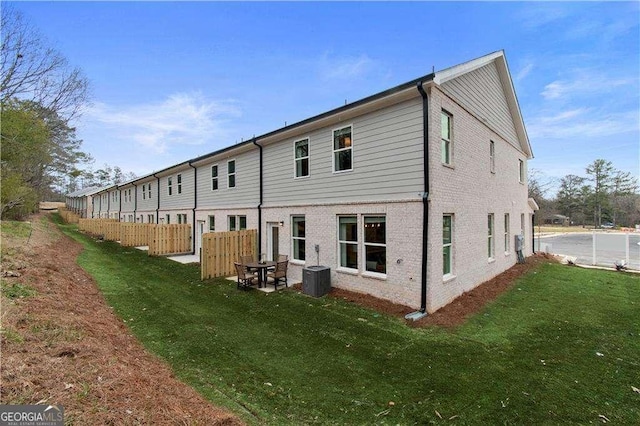 back of property with a lawn and central air condition unit