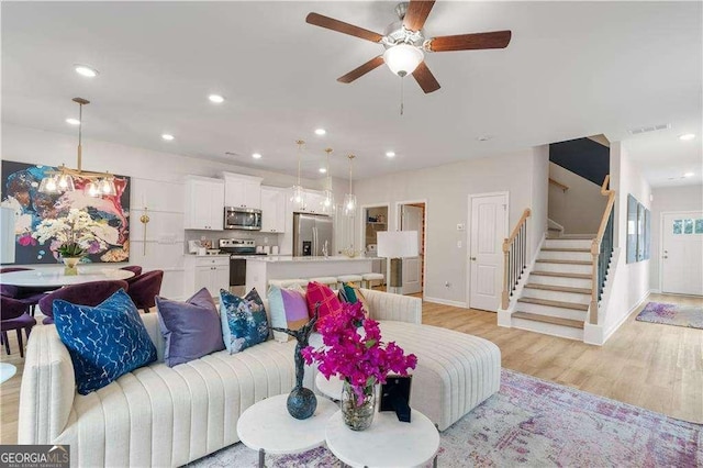 living room with ceiling fan and light wood-type flooring