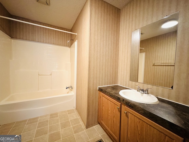 bathroom featuring vanity, washtub / shower combination, and a textured ceiling