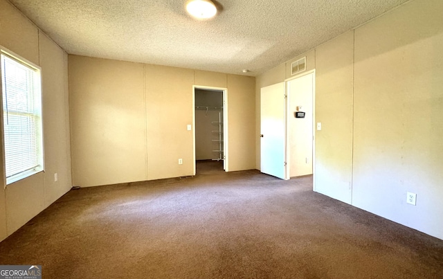 spare room featuring carpet floors and a textured ceiling