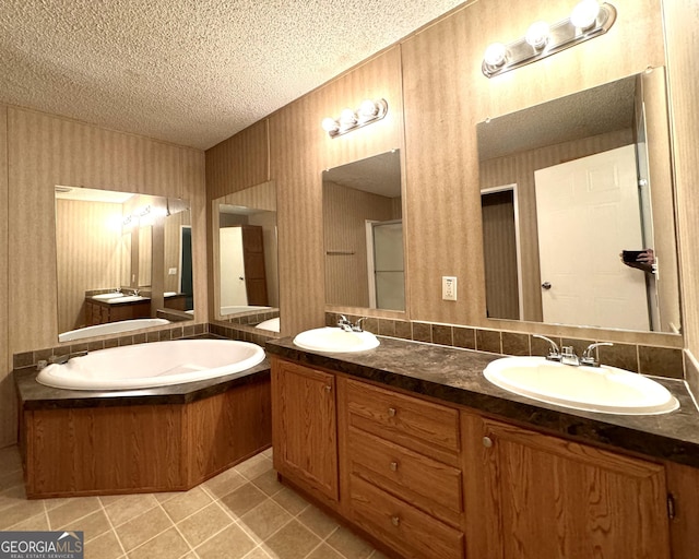 bathroom featuring tile patterned floors, vanity, a textured ceiling, and a tub