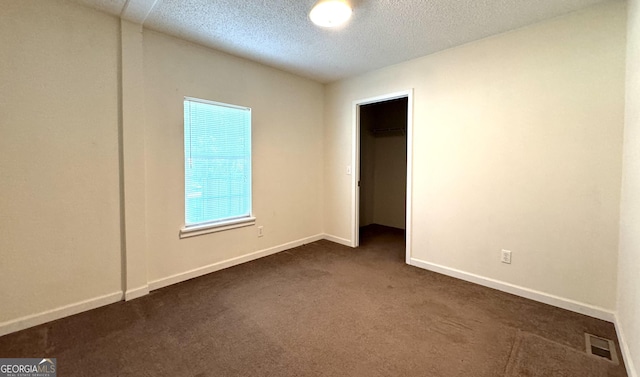 carpeted spare room featuring a textured ceiling