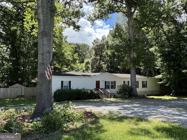 view of front facade featuring a storage shed and a front yard