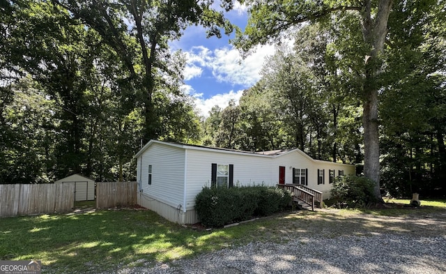 view of front of home with a front yard and a storage shed