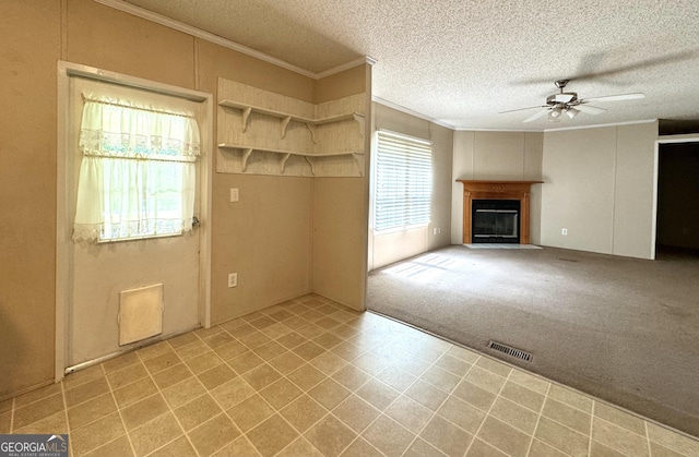 interior space featuring a textured ceiling, ceiling fan, light colored carpet, and crown molding