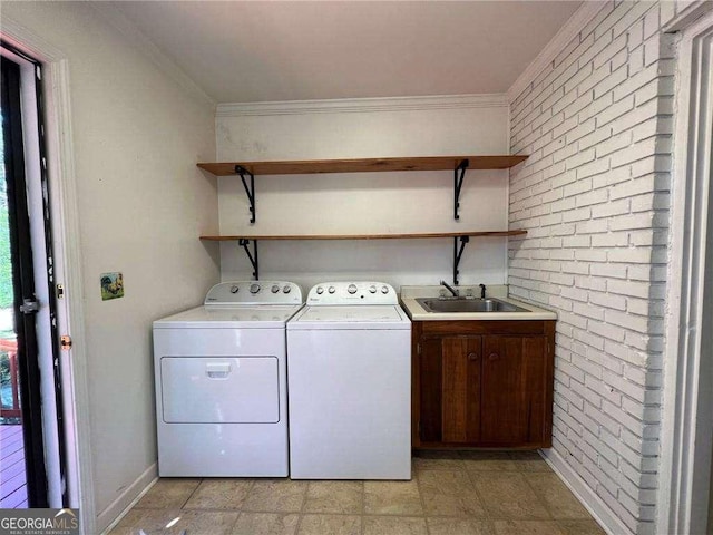 laundry area with cabinets, ornamental molding, brick wall, sink, and separate washer and dryer