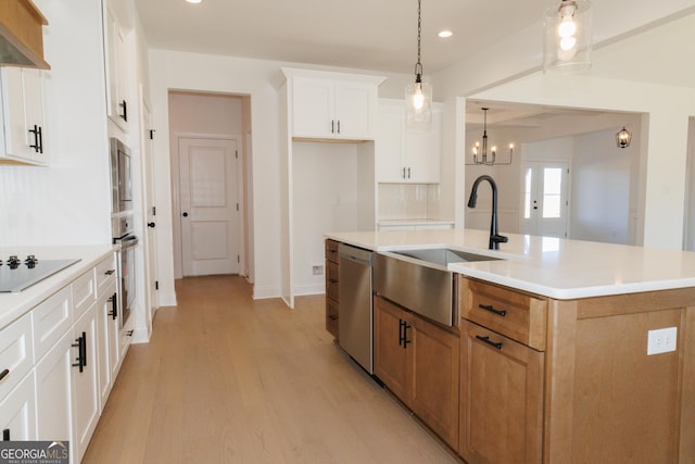 184 Grove Park Unit 11, Senoia, GA 30276 - kitchen featuring appliances with stainless steel finishes, a sink, light wood-type flooring, ventilation hood, and a kitchen island with sink