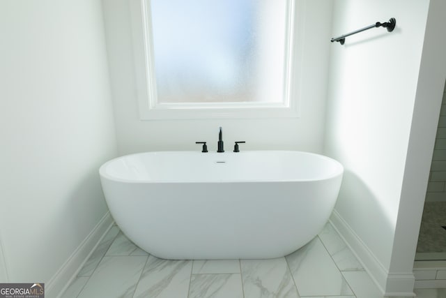184 Grove Park Unit 11, Senoia, GA 30276 - full bathroom with marble look tiles, baseboards, and a freestanding tub