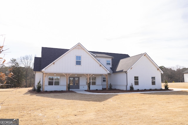 view of front of property with french doors and a front lawn