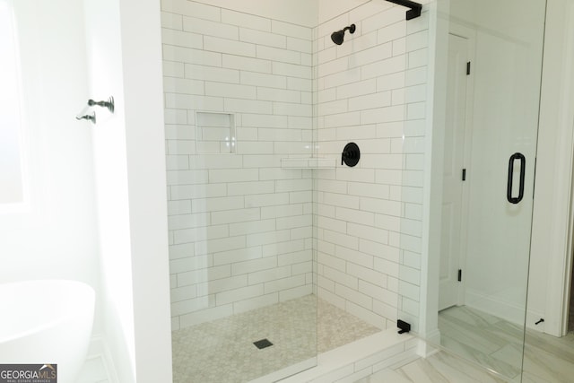 184 Grove Park Unit 11, Senoia, GA 30276 - full bath featuring a stall shower, a freestanding tub, and marble finish floors