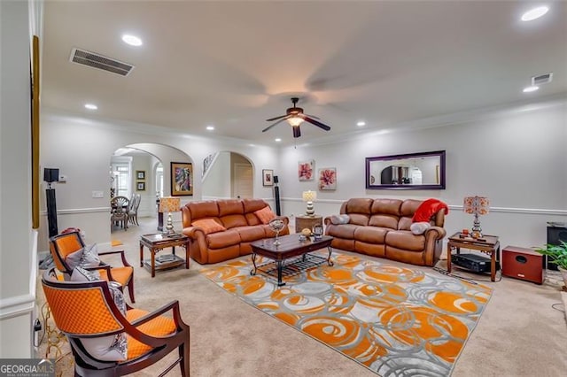 living room featuring ceiling fan, light carpet, and ornamental molding