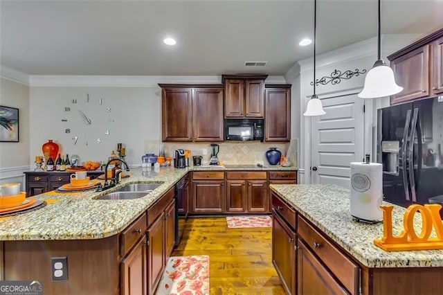 kitchen featuring pendant lighting, black appliances, crown molding, sink, and light wood-type flooring