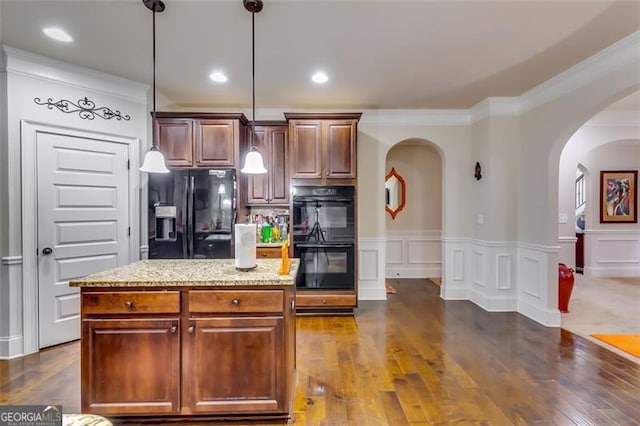 kitchen with black appliances, decorative light fixtures, a kitchen island, and ornamental molding