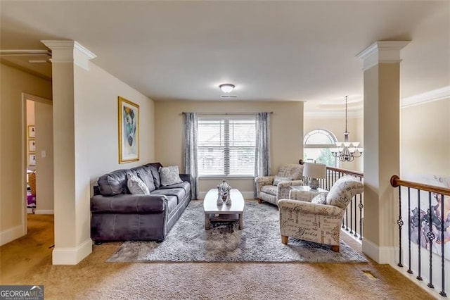 living room with ornate columns, carpet floors, ornamental molding, and an inviting chandelier