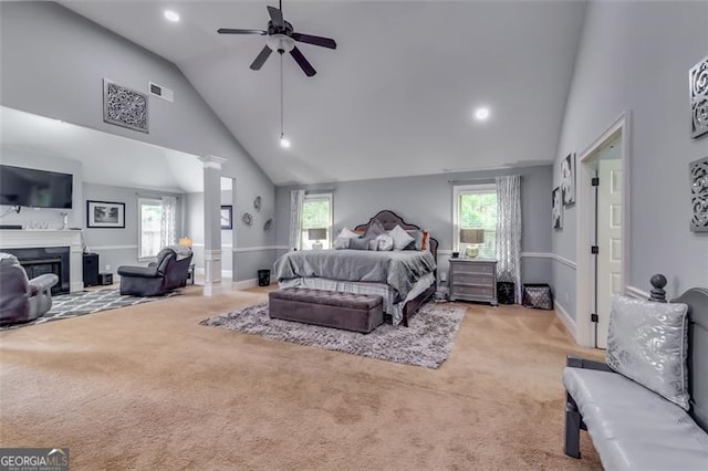 carpeted bedroom with multiple windows, ceiling fan, and high vaulted ceiling